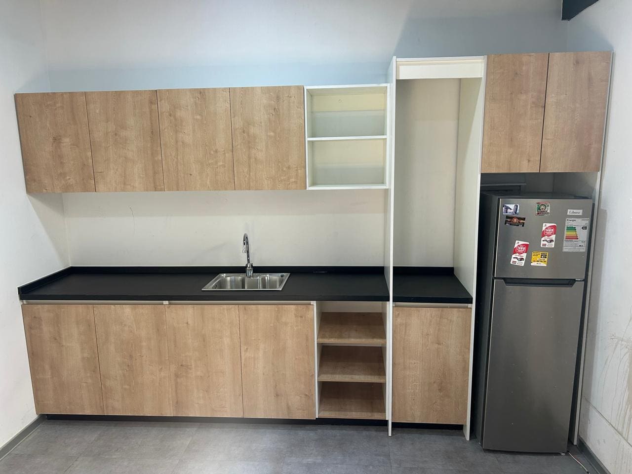 Cocina a medida con muebles blancos, cubierta oscura y mesa auxiliar abatible ya instalada